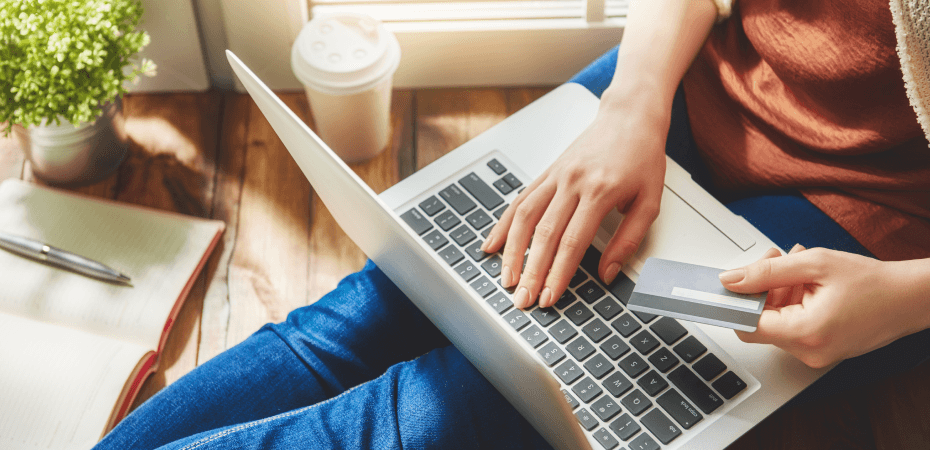 A person holding credit card with laptop